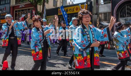 Volkstänzer in bunten Yukata tanzen in Shibuya Kagoshima Ohara Matsuri Festival in der Straße von Shibuya, Tokyo, Japan. Stockfoto