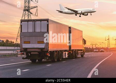Güterwagen bewegt sich auf der Autobahn und Flugzeug vor der Landung bei Sonnenuntergang Zeit. Stockfoto