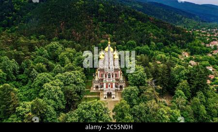Luftaufnahme der östlichen orthodoxen Kirche, die von a umgeben ist Wunderschöner Wald Stockfoto