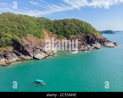 Schöner geheimer Strand Butterfly in Goa, Indien. Luftaufnahme des unberührten Strandes mit felsigen Bucht und Wellen, die zusammenbrechen. Stockfoto