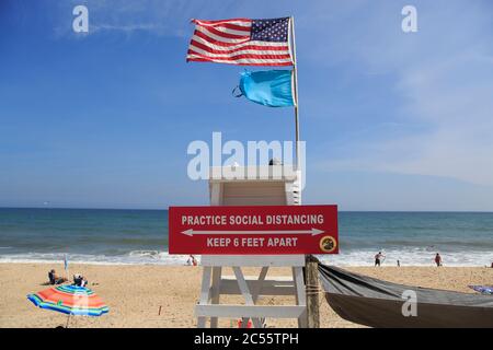 Üben Sie ein soziales Distanzierungsschild am Rettungsschwimmer am öffentlichen Strand in Montauk, das die Menschen daran erinnert, sechs Meter auseinander zu halten, um die Ausbreitung des Coronavirus COVID-19, Edison Beach, Long Island, New York, USA zu verhindern Stockfoto