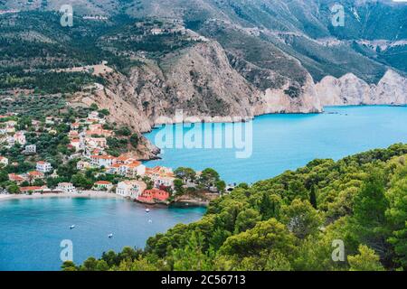 Assos niedliches Dorf auf der Insel Kefalonia, Griechenland. Schöne bunte Stadt am Ufer mit Bay Lagoon, Kiefern und Zypressenbäumen, felsiger Küste. Stockfoto