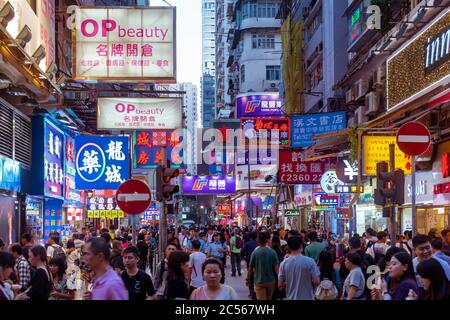 Neon-Schaufensterschilder beleuchten die überfüllten Straßen des berühmten Viertels Mong Kok in Hongkong. Stockfoto