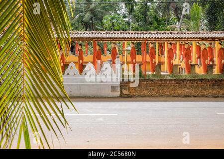 Viele Statuen buddhistischer Mönche stehen in einer langen Linie an einer Wand, Sri Lanka Stockfoto