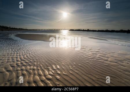 Schönes Wellenmuster auf dem Stand und bewegte Wolken im Winter am Ufer der Ostsee Stockfoto