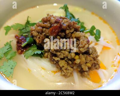 Hackfleisch mit Gemüse auf den chinesischen traditionellen Reisnudeln mit weißer Suppe zum Frühstück Stockfoto