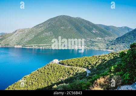 Kristallklares Wasser, riesige Hügel, die mit Wasserfarben, Kiefern und Olivenbäumen überwuchert sind. Atemberaubender Blick auf die mittelmeerküste Griechenlands. Stockfoto