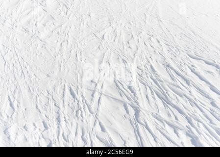 3 - sanft geschwungene lineare Bahnen von abwesenden Skifahrern links überqueren in ein kompliziertes Gittermuster in der reinen weißen alpinen Schnee, Hintergrundstruktur Stockfoto