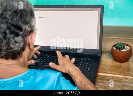 Ältere Frau tippen auf einem Laptop Dinge zu tun Stockfoto
