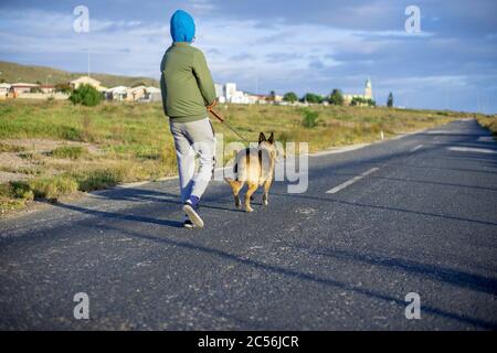 Kleiner Junge, der seinen deutschen Schäferhund zu Fuß nimmt Stockfoto