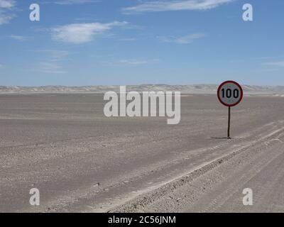 Sonnige Landschaft einer Wüstenstraße mit einem Tempolimit Wegweiser in Skeleton Coast, Namibia, Afrika Stockfoto