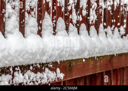 Ländliche Holzzaun bedeckt mit frisch gefallenen Schnee. Stockfoto