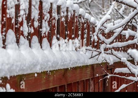 Ländliche Holzzaun bedeckt mit frisch gefallenen Schnee. Stockfoto