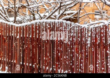 Ländliche Holzzaun bedeckt mit frisch gefallenen Schnee. Stockfoto