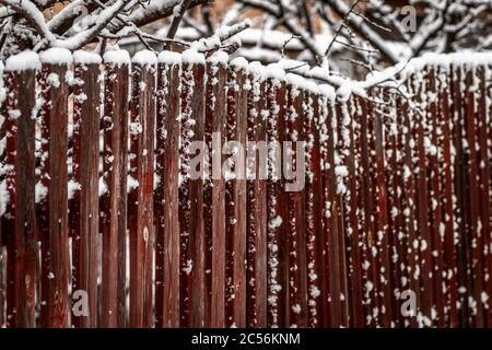 Ländliche Holzzaun bedeckt mit frisch gefallenen Schnee. Stockfoto