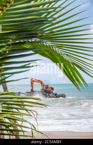 Bagger auf einem Felsbrecher an der Küste von Sri Lanka Stockfoto