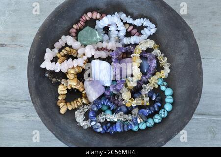 Viele Armbänder aus bunten Edelsteinen und Kristallen in Eine schwarze Schale Stockfoto