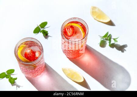 Limonade mit Erdbeeren und Minze in Gläsern auf weißem Hintergrund. Blick von oben Stockfoto