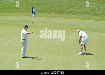 ST. CHARLES, VEREINIGTE STAATEN - Jun 29, 2006: Männer auf dem Golfplatz Green Putting Stockfoto