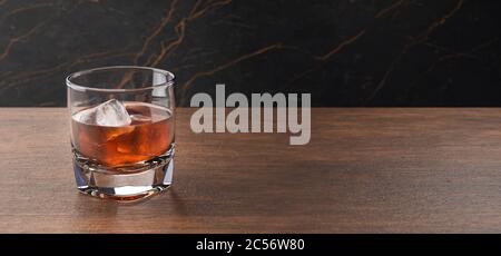 Glas Scotch Whiskey und Eis. Whisky, Bourbon, Brandy oder Rum auf Holztisch. Glas mit Alkoholgetränk. Stockfoto