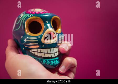 Männliche Hand hält traditionelle mexikanische dekorative Schädel oder Calaveras Stockfoto