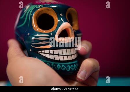 Männliche Hand hält traditionelle mexikanische dekorative Schädel oder Calaveras Stockfoto