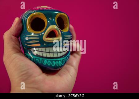 Männliche Hand hält traditionelle mexikanische dekorative Schädel oder Calaveras Stockfoto