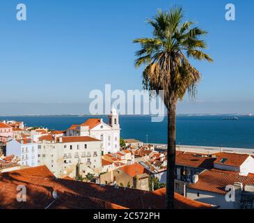 Lissabon, Portugal. Blick über den alten Stadtteil Alfama mit der Kirche Santo Estevao nach rechts und den Rio Tejo, oder Tejo Fluss, dahinter. Stockfoto