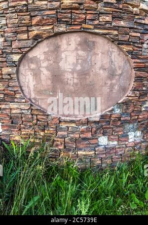 Stelle für eine ovale Tablette auf einer dekorativen Steinwand. Stockfoto