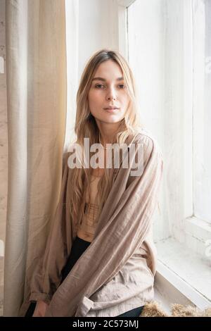Portrait selbstbewusst, schöne junge blonde Frau im Fenster Stockfoto