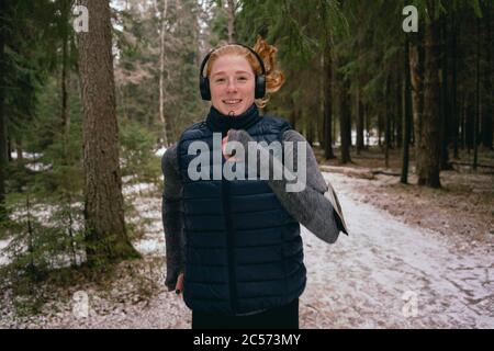 Portrait selbstbewusste Frau läuft in verschneiten Wäldern Stockfoto