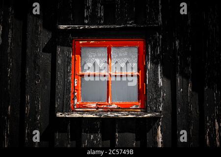 Rotes Fenster auf einer Holzhütte in Skandianvien Stockfoto