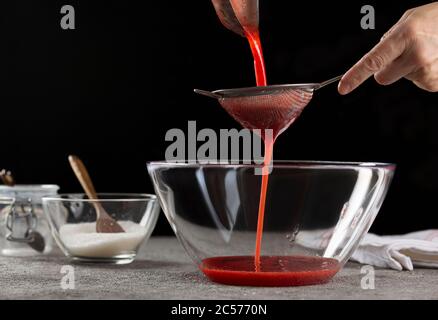 Sieb Sirup Herstellung Erdbeermarmelade Gießen Erdbeer Sirup, close up Stockfoto
