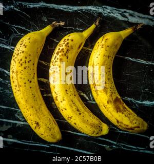 Drei Bananen auf einem Marmortisch Stockfoto