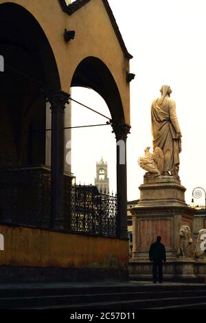 Santa Croce, Florenz, Italien. Die Statue des Dichters Dante Alighieri von hinten, beleuchtet vom Sonnenlicht Stockfoto