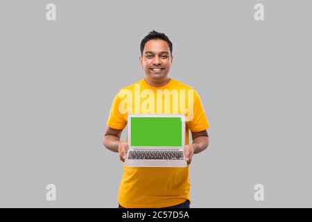 Delivery Man Zeigt Laptop Green Screen. Home-Bestellungen, Quarantäne-Lieferung, Online-Shopping, Freiberufler-Konzept. Stockfoto