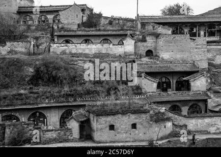 Morgen in Lijiashan Dorf der Provinz Shanxi mit Stein Eingänge zu den Höhlenwohnungen umarmt die steilen Hänge Stockfoto