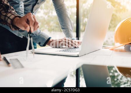 Architekt diskutiert neues Projekt und den Einsatz von Laptop mit Kollegen im Büro. Stockfoto