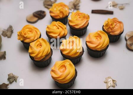 Herbstbonbons, Cupcakes auf einem Tisch mit getrockneten Blättern und Kürbis. Hausgemachte Leckereien. Stockfoto
