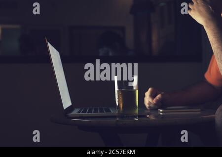 Männer trinken Bier, während sie Laptops ansehen, die gestresst und traurig sind. Stockfoto