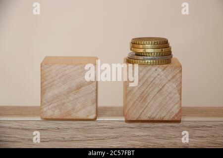 Zwei Holzwürfel mit Münzen auf einen Würfel. Trockenbau Konzept in der Wirtschaft oder Karriere Stockfoto