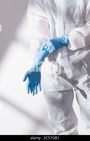 COVID-19, Virus, Schutzanzug, Handschuhe, anziehen, Detailansicht Stockfoto