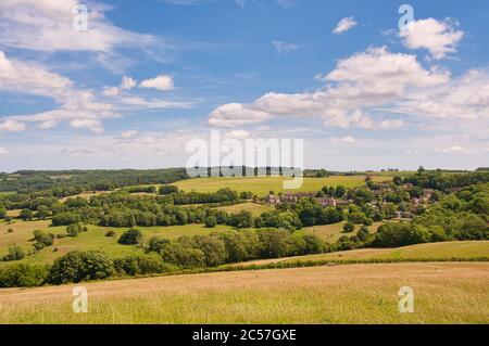 Blick über sanfte Hügel auf das Gloucestershire-Dorf Snow Hill in den Cotswolds. Stockfoto