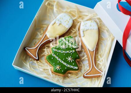 Weihnachten Neujahr Urlaub Hintergrund, campagne Gläser und weihnachtsbaum Lebkuchen verpackt in Box auf blauem Hintergrund Urlaub Konzept. Stockfoto