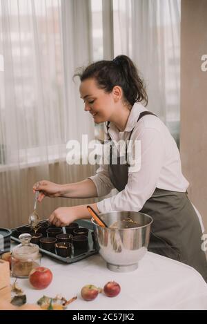 Der Bäcker schafft Cupcakes in Formen. Der Bäcker schafft Karotten Muffins. Stockfoto