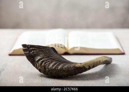 Rosh Hashanah (Hashana) (jüdisches Neujahrsfest) Konzept mit RAM Shofar (Horn) mit religiösem heiligen Gebetsbuch auf Tisch Stockfoto