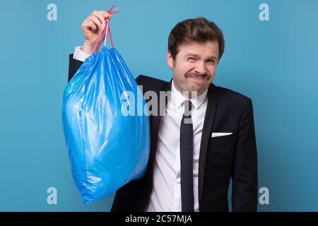 Mann in Anzug mit blauem Müllbeutel Stockfoto