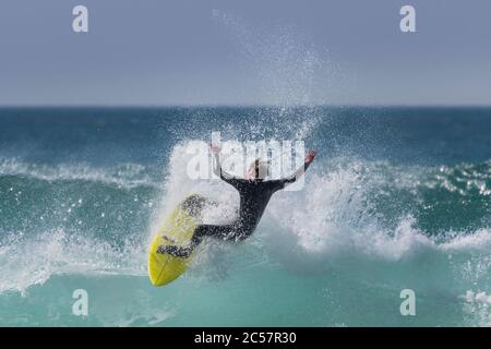 Wilde spektakuläre Action als Surfer reitet eine Welle am Fistral in Newquay in Cornwall. Stockfoto