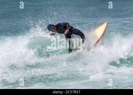 Spektakuläre Action, während ein Surfer eine Welle in Fistral in Newquay in Cornwall reitet. Stockfoto