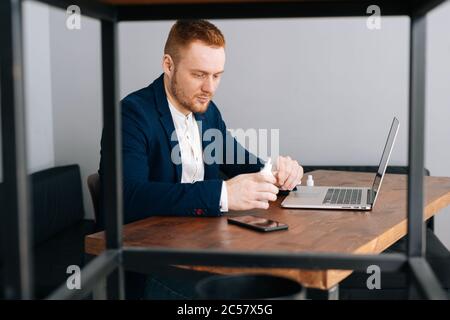 Schöne junge Geschäftsmann tragen Mode Anzug ist die Anwendung Desinfektionsmittel Stockfoto